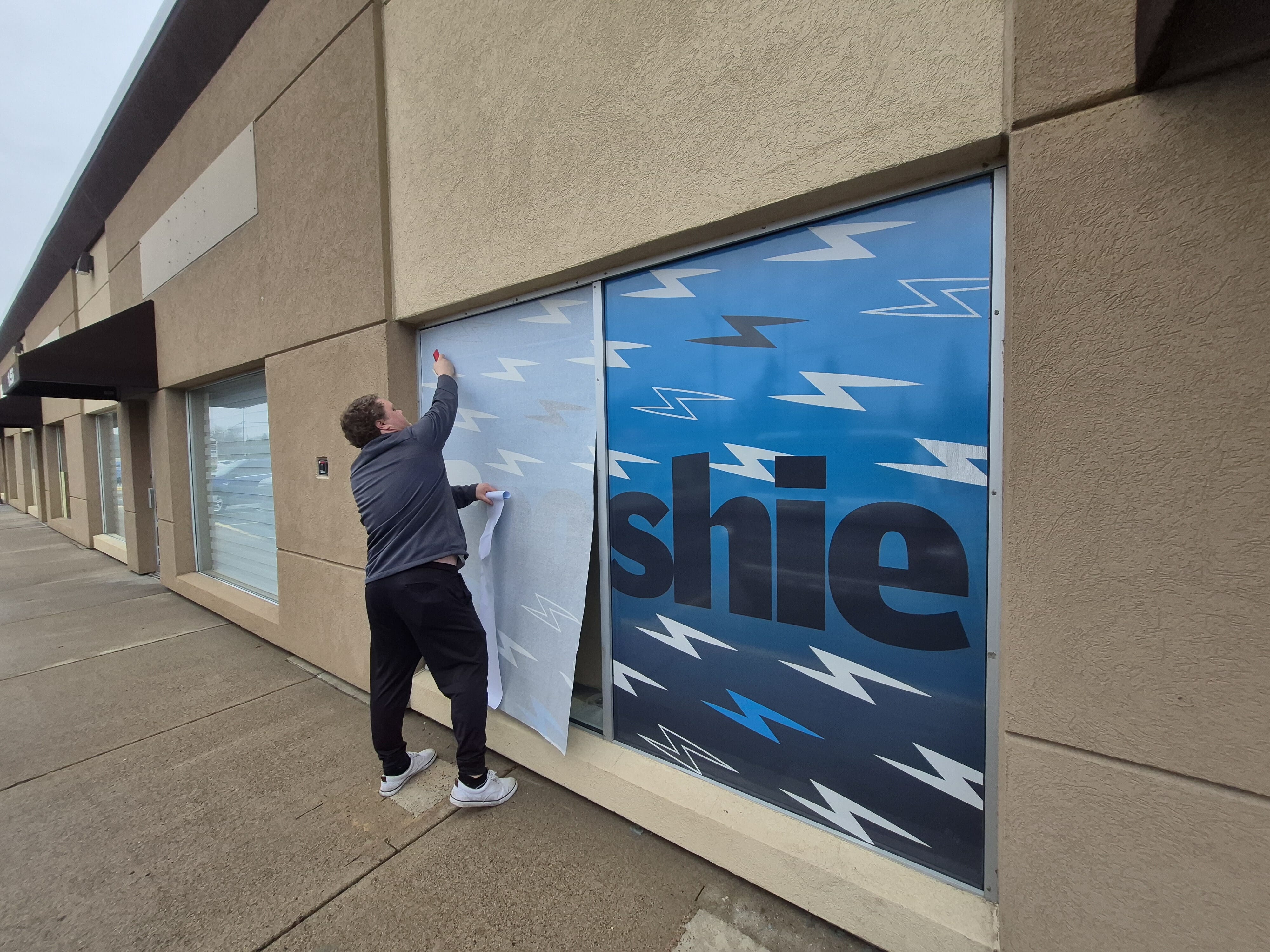 window graphic installation for Booshie Graphics storefront